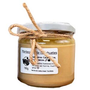 Ein 180-ml-Glas mit Erdnussbutter, weißem Deckel und Bindfadenschleife, auf dem in spanischer Sprache die Zutaten und das Verfallsdatum angegeben sind.